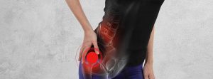 Causas del dolor de cadera: deportista con la mano sobre la cadera y un circulo rojo