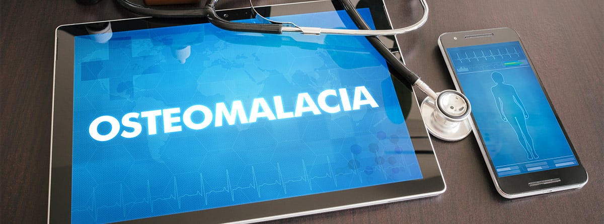 tablet con la palabra osteomalacia, teléfono y fonendoscopio