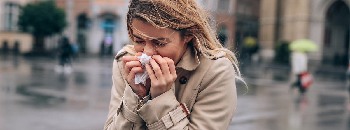 Alergia al drío: mujer con un pañuelo en la nariz en invierno