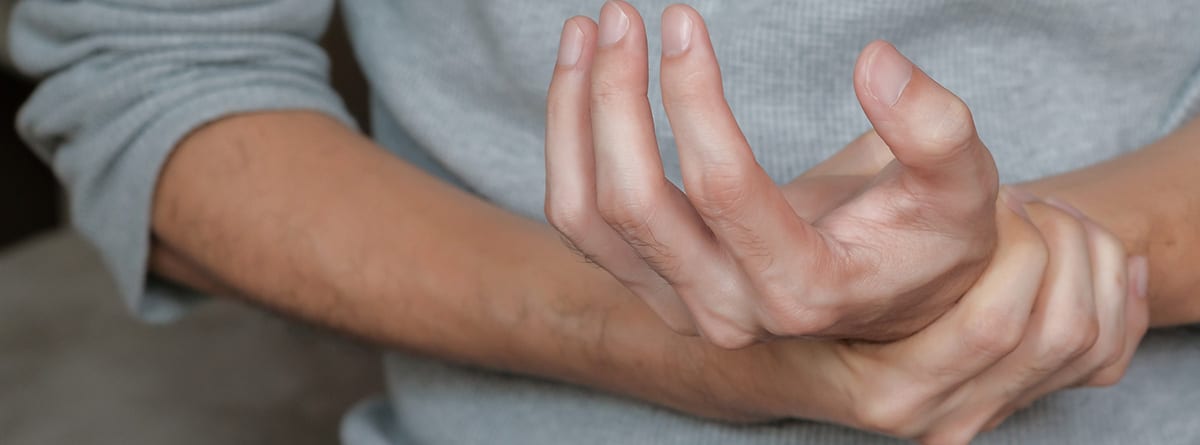 Artralgias y la vacuna anticovid: manos de hombre con dolor
