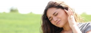 Barotraumatismo: qué es y cómo se cura: mujer sufriendo del dolor de oídos