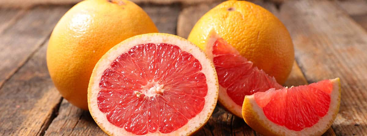 Beneficios del pomelo: pomelos enteros, partidos por la mitad y en gajos