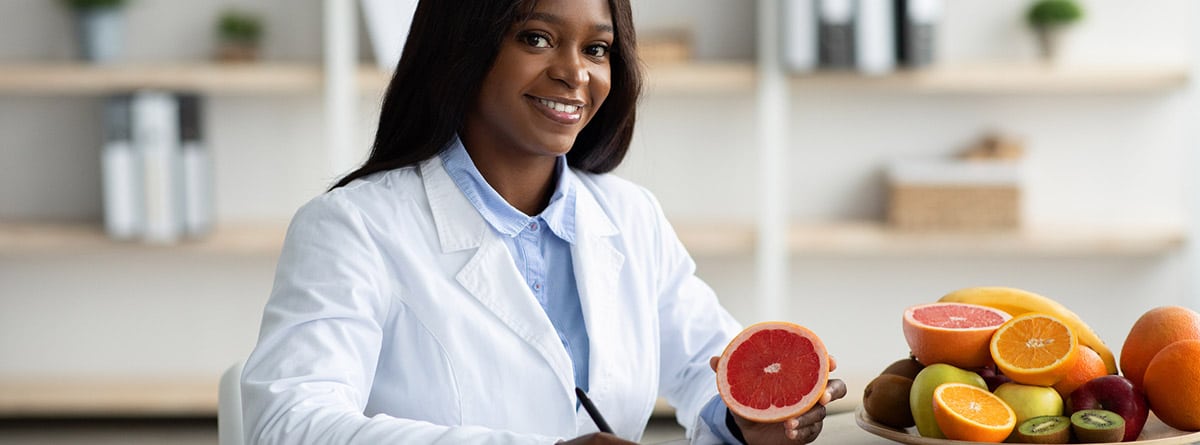 Beneficios del pomelo para la salud: doctora en consulta con un pomelo en la mano