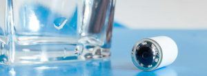 Endoscopia capsular: vaso de agua y una cápsula endoscópica