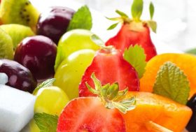 Brochetas de frutas en un plato blanco