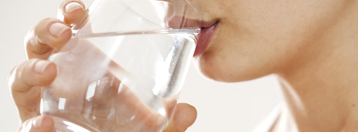 Mujer joven bebiendo un vaso de agua