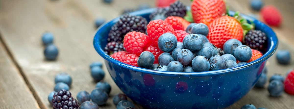 Bol azul con moras, fresas, arandanos y frambuesas