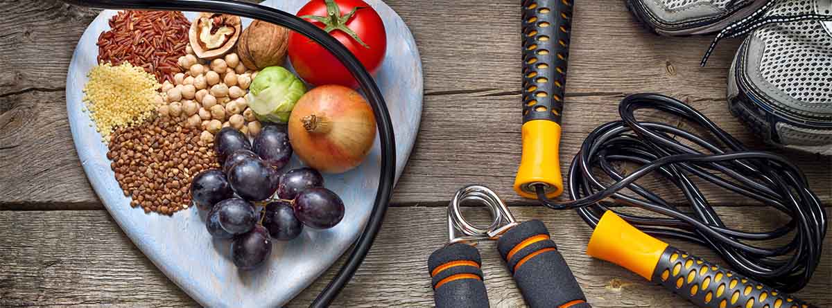 mesa con plato en forma de corazón con frutas y semillas y aparatos para ejercicio