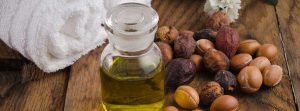 Aceite de argán Beneficios para la piel y el pelo: Bodegón de aceite de argán con frutas sobre un fondo natural
