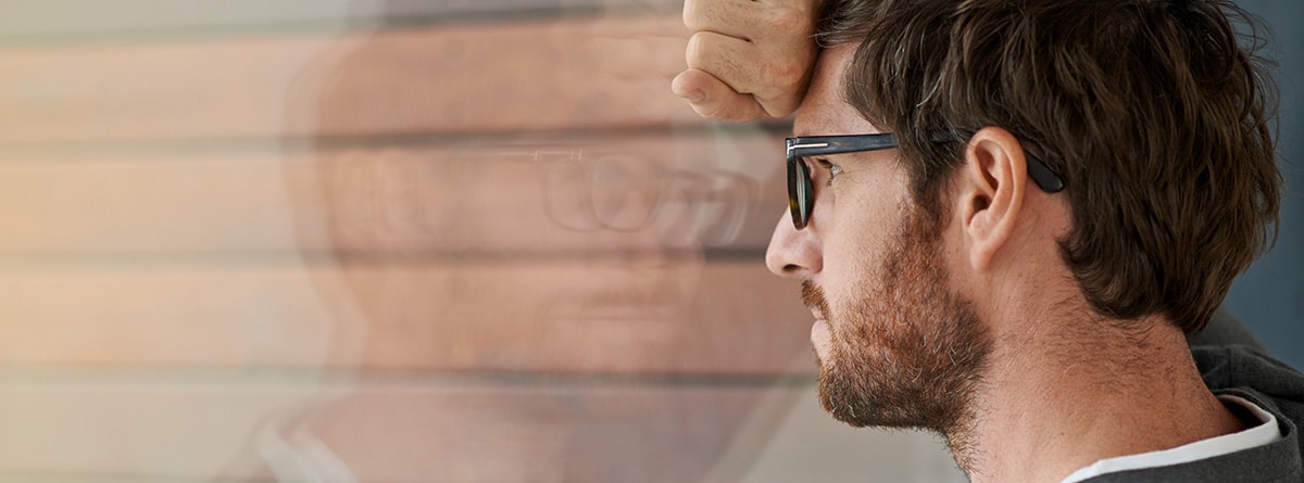Diferencias entre ansiedad y depresión: hombre apoyando la cabeza en la pared con actitud triste