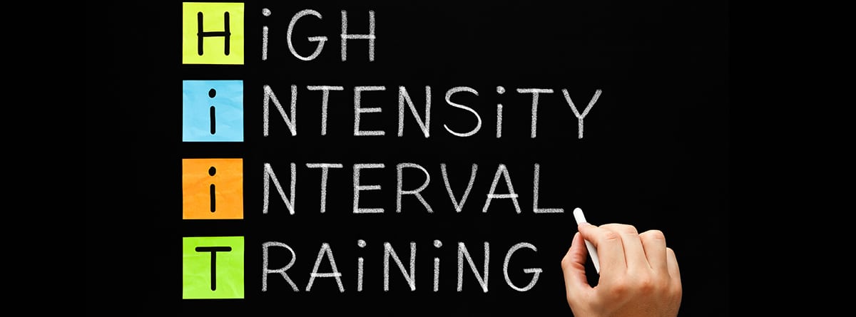 Qué es el HIIT: 5 ejercicios para principiantes, Escritura a mano acrónimo de entrenamiento físico HIIT - Entrenamiento en intervalos de alta intensidad con tiza blanca en la pizarra
