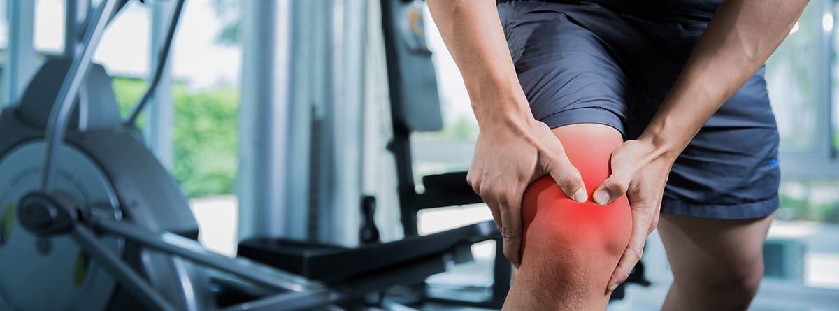 hombre en el gimnasio con una lesión en el cuádriceps