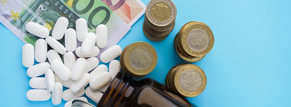 concepto de precios de medicamentos, frasco con pastillas, monedas y billetes de cien y cincuenta euros