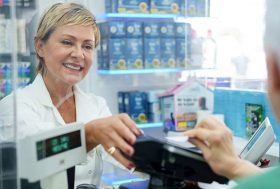 Persona mayor comprando medicamentos en una farmacia