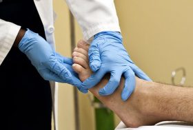 especialista en traumatología palpando el pie para un diagnóstico