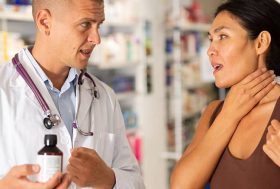 Farmacéutico enseñando un medicamento a una mujer con dolor de garganta
