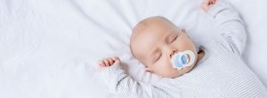 Bebé durmiendo con un chupete en la boca
