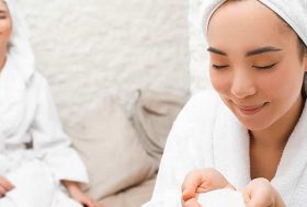 Dos mujeres con albornoz blanco y toalla den la cabeza recibiendo una sesión de haloterapia
