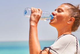 Mujer joven y deportista bebiendo de una botella de agua