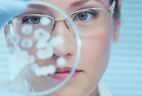 Mujer revisando bacterias en un laboratorio.