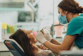Dentista atendiendo a una mujer en su consulta