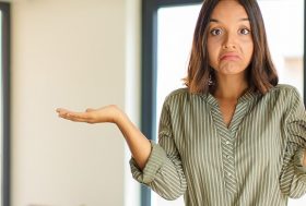 Mujer confundida elevando hombros