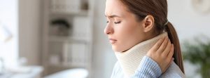 Mujer con collarín y dolor en el cuello