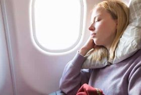 Mujer joven durmiendo en un avión