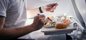 Pasajero de avión comiendo a bordo