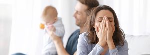 Mujer llorando mientras su pareja sostiene al bebé