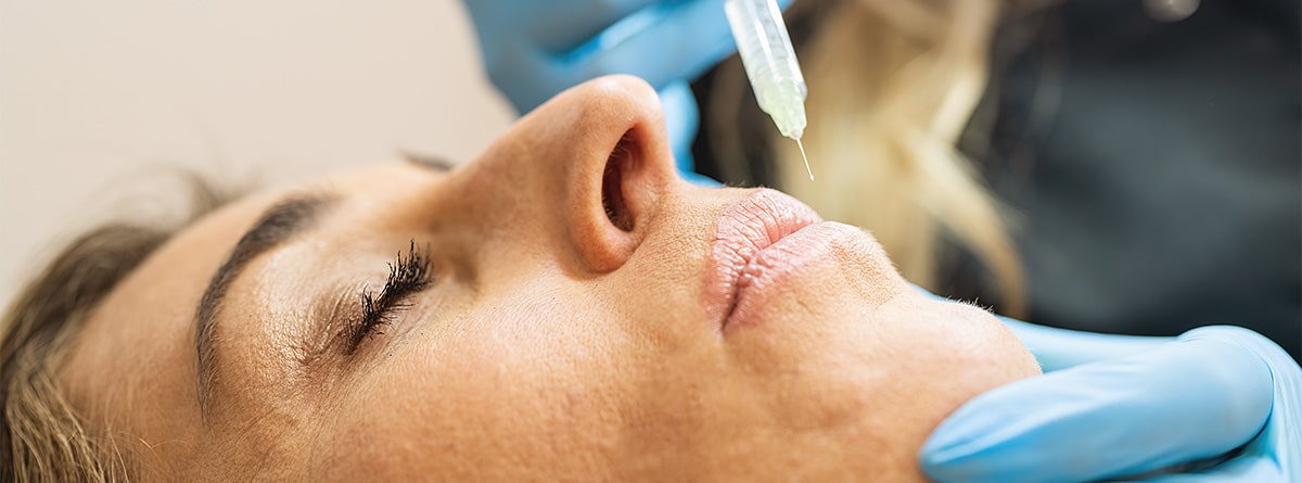 Mujer inyectándose labios