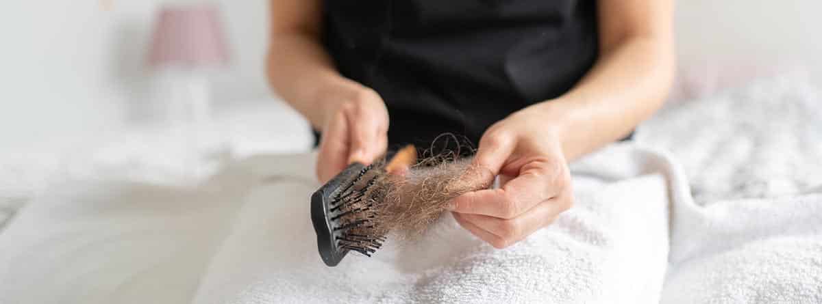 Mujer limpiando cepillo del cabello