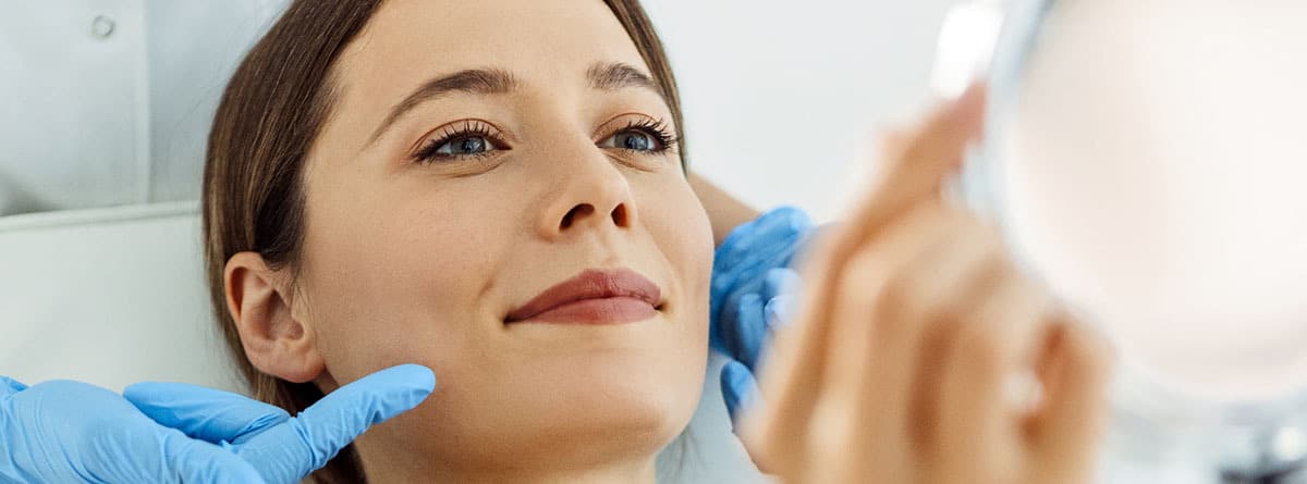 Mujer sonriente recibiendo un tratamiento de bioestimuladores de colágeno