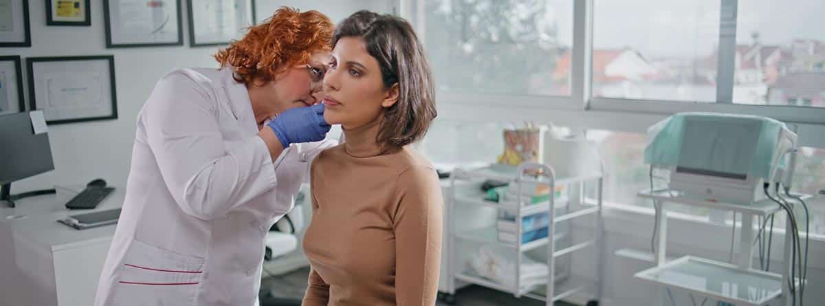 Mujer siendo revisada por una otorrino