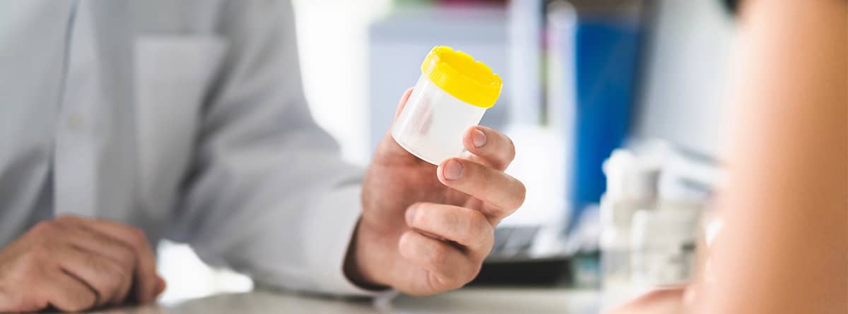 Doctor enseñando el bote de muestra