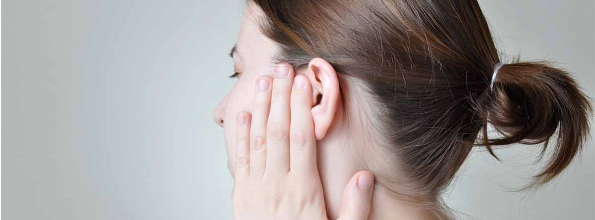 Mujer sujetándose la oreja de dolor