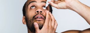 Hombre echándose colirio ojos