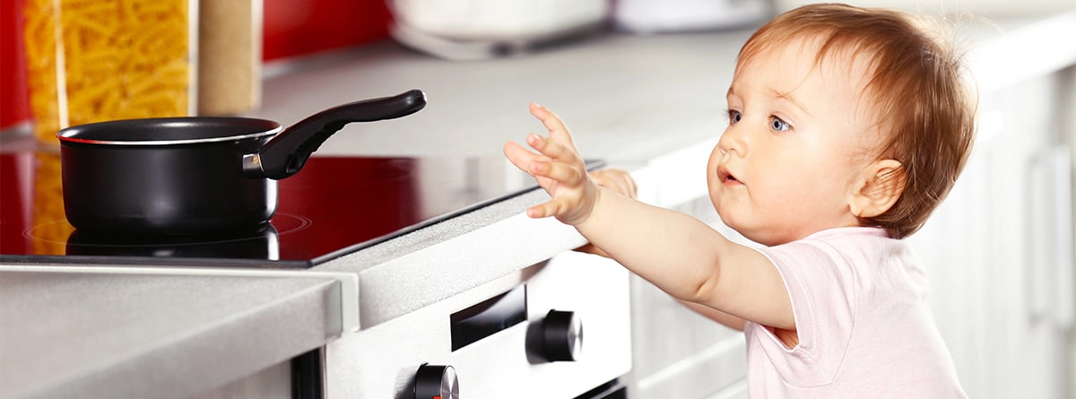 Bebé en la cocina con un feugo encendido