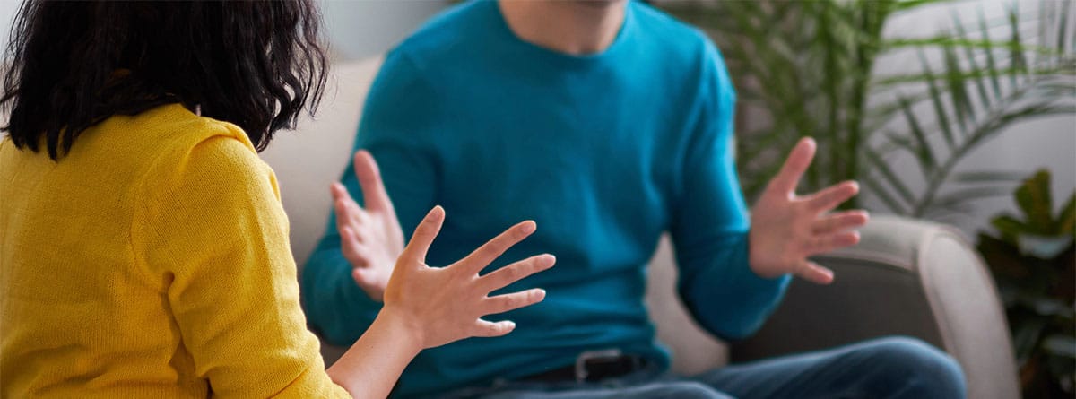 Dos personas discutiendo en el sofá
