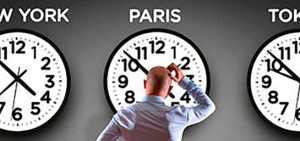 Hombre delante de relojes de otros paises con otras zonas horarias