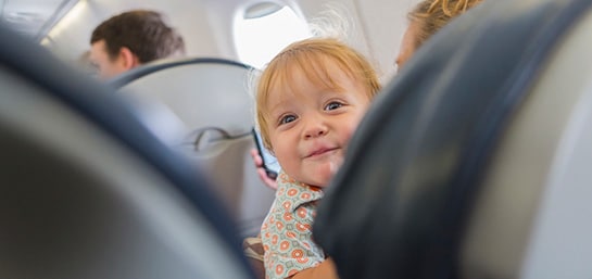 viajar-en-avion-con-un-bebe bebe en un avión sonriente