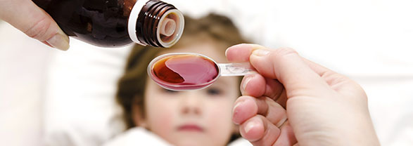 Aspergilosis: qué es, síntomas y tratamiento Un niño acostado observa cómo una mujer adulta sirve una medicina en una cuchara