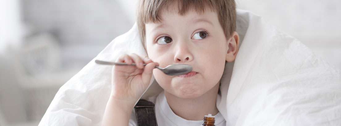 Candidiasis en el bebé Niño recostado toma una cucharada de medicina