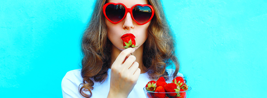 ingesta alimenaria efectos de la fibra chica con gafas de sol rojas comiendo fresas