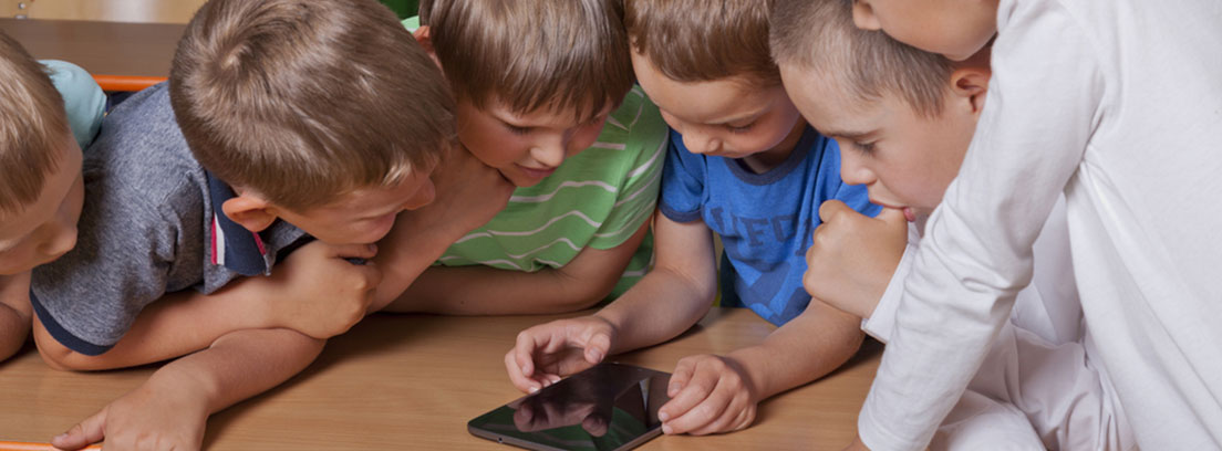 El juego de 6 a 12 años Grupo de niños jugando con una tablet