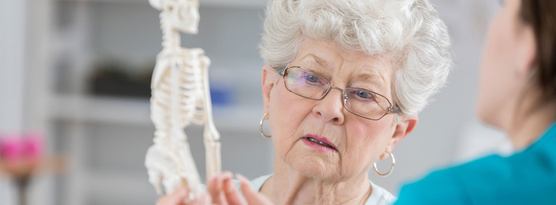 La osteoporosis se trata de una enfermedad que algunos autores han definido como una auténtica epidemia; una epidemia silenciosa que supone numerosos costes personales y sociales, fundamentalmente derivados de su principal consecuencia: las fracturas óseas. Esta enfermedad afecta a un número considerable de individuos (se calcula que en España hay aproximadamente tres millones de personas con osteoporosis), siendo más frecuente entre los mayores y los ancianos. La consecuencia más temida en la osteoporosis es la fractura y, secundariamente, la dependencia, formando un problema sociosanitario y económico de primera magnitud. Una enfermera le enseña un esqueleto a una señora mayor