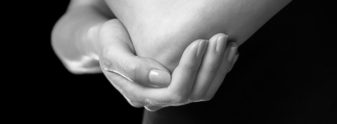Tendinitis: codo de tenista y golfista Mano de mujer sujetando el codo