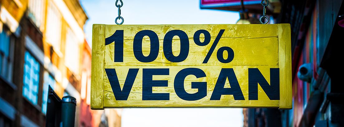 Recetas veganas muy parecidas a las originales cartel amarillo de madera colgado de comida vegana