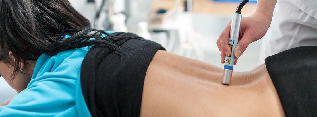 punto-gatillo-compressor mujer tumbada en sesión de fisioterapia