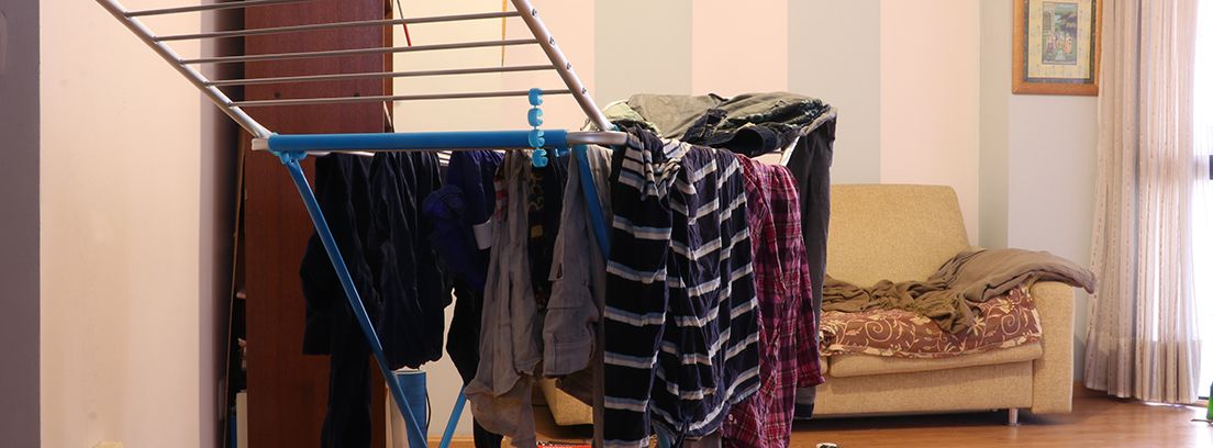 tender-dentro-de-casa tendedero con ropa en el salón